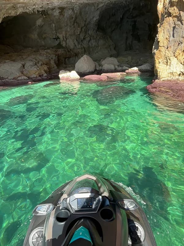 Moto de agua navegando frente a una costa rocosa