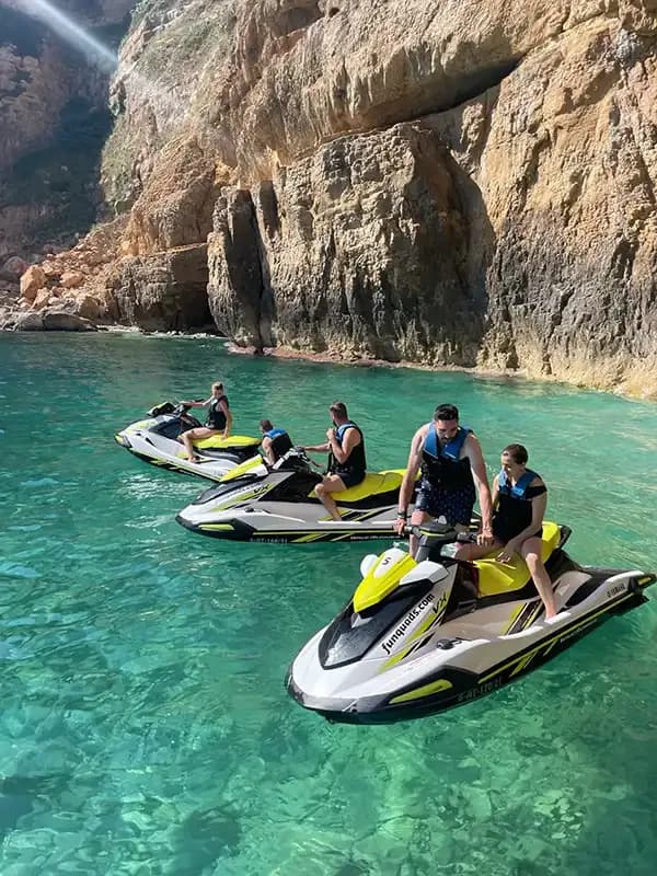 Grupo en motos de agua junto a una cala mediterránea