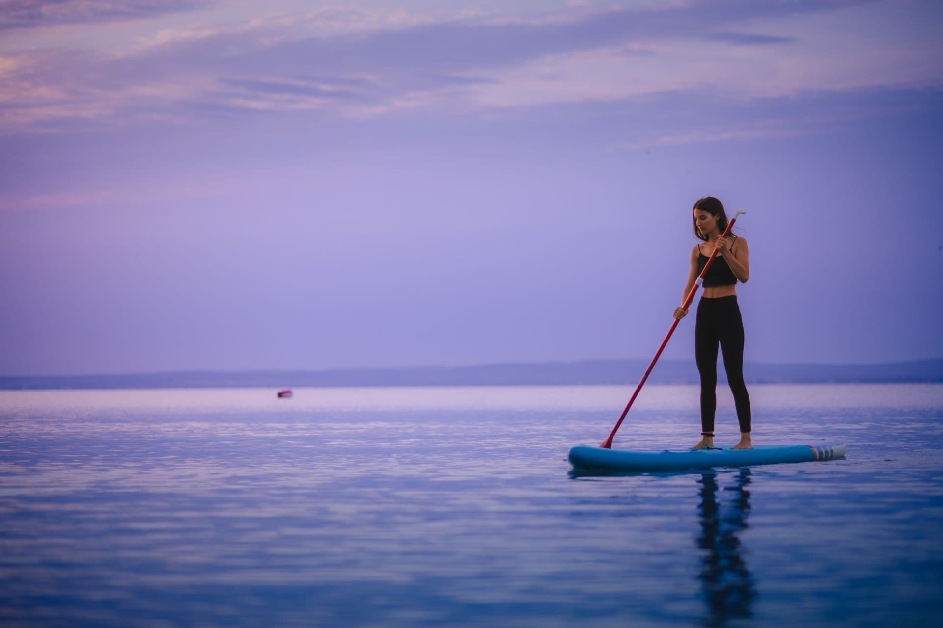 Persona remando sobre una tabla de paddle surf